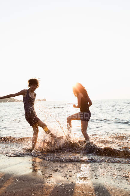 Женщины играют волнами на пляже — стоковое фото