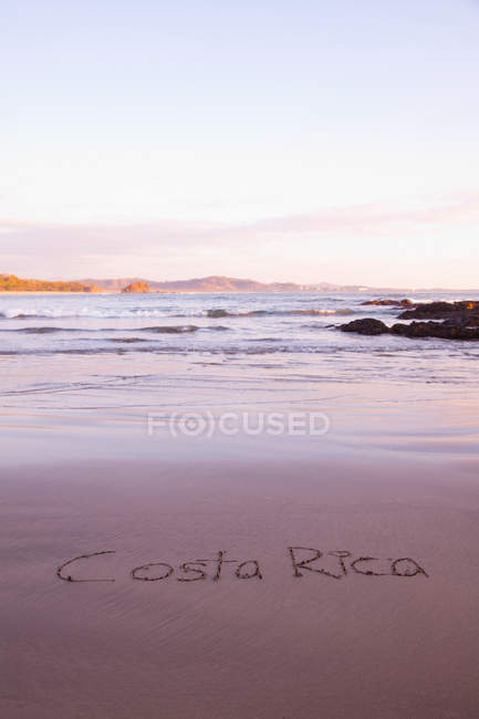 Costa rica in sand auf bea geschrieben — Stockfoto