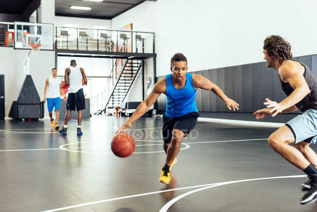 Dois jogadores de basquete do sexo masculino praticando defesa de bola na quadra de basquete — Fotografia de Stock