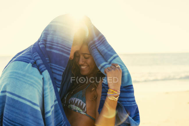 Couple wrapped in blanket at Newport Beach, California, USA — Stock Photo