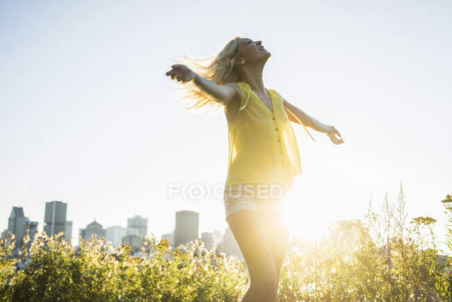 Retrato de bela menina loira dançando com paisagem urbana para trás durante o verão — Fotografia de Stock