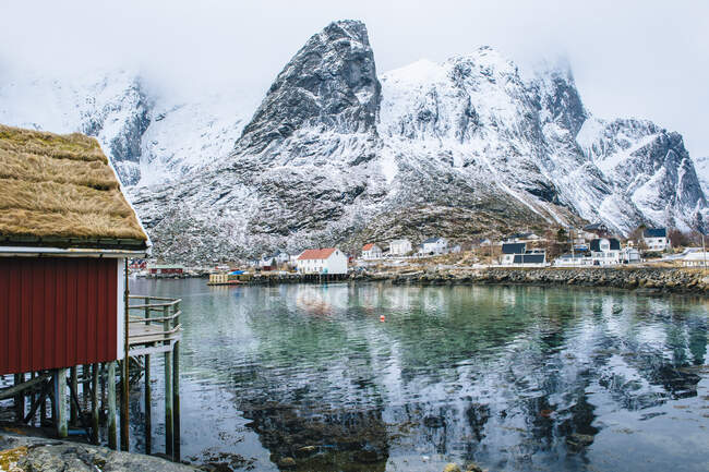 Bâtiments et montagnes enneigées, Reine, Lofoten, Norvège — Photo de stock