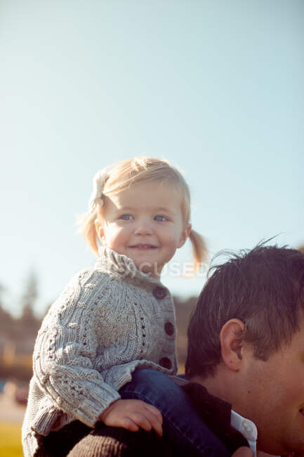 Criança feminina nos ombros do pai — Fotografia de Stock
