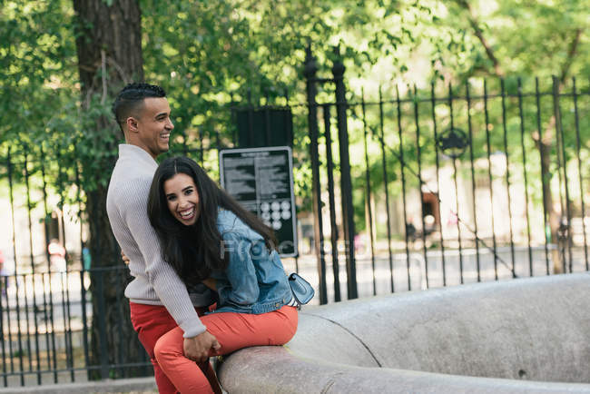 Взрослая пара смеется друг с другом в городском парке — стоковое фото