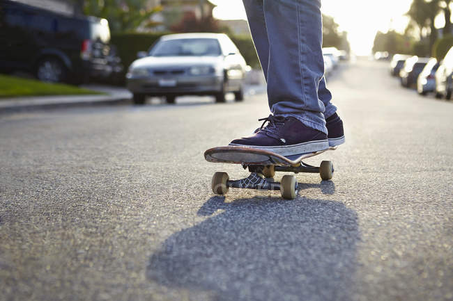 Хлопчик скейтбординг на дорозі, крупним планом частковий вид — стокове фото