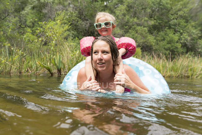 Mother and daughter with inflatable ring in lake, Niceville, Florida, USA — Stock Photo
