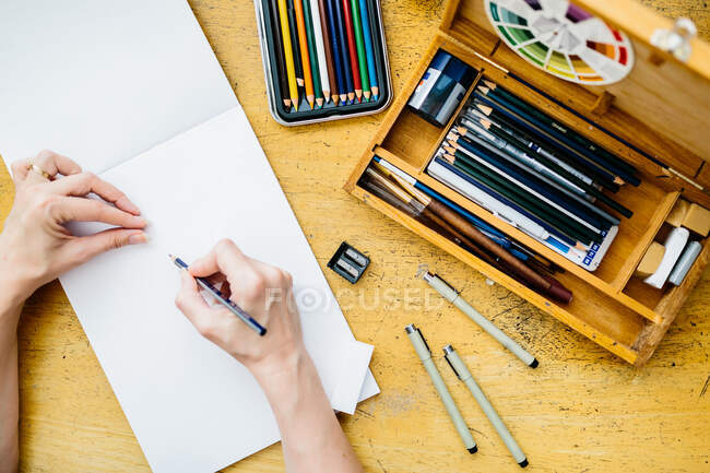Художник держит карандаш, вот-вот начнет рисовать, вид сверху — стоковое фото