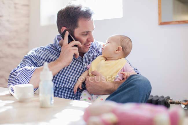 Pai no celular com bebê filha — Fotografia de Stock