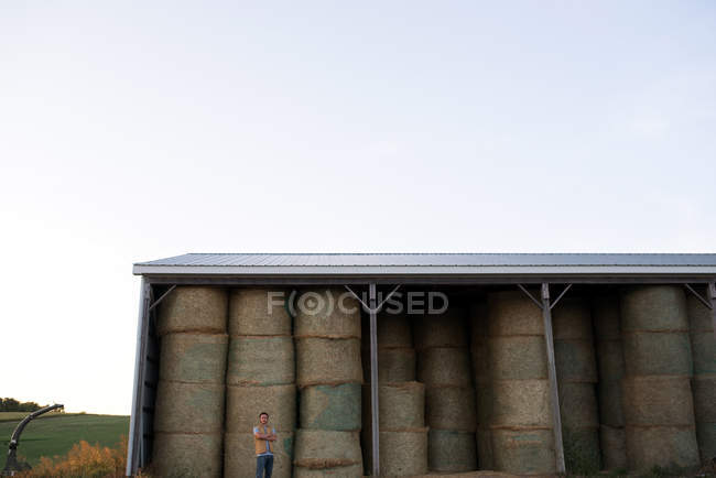 Portrait of farmer, standing in front of hay shed — Stock Photo