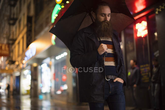 Homem andando na cidade à noite, usando guarda-chuva, Downtown, San Francisco, Califórnia, EUA — Fotografia de Stock