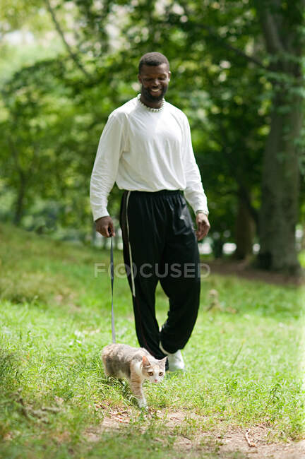 Homme marchant un chat — Photo de stock