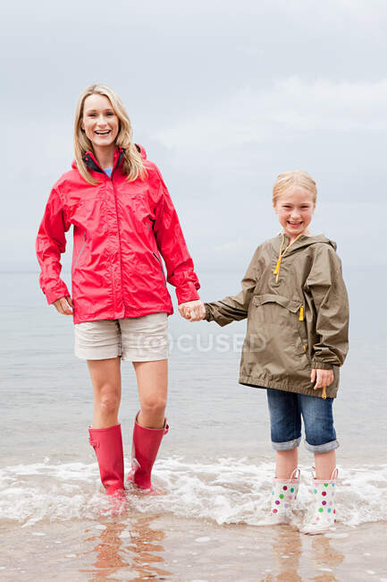 Мать и дочь стоят в море — стоковое фото