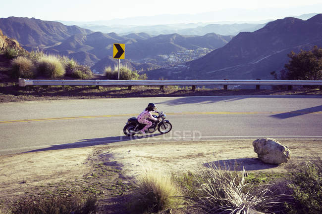 Man wearing pyjamas and riding motorcycle, Malibu Canyon, California, USA — Stock Photo