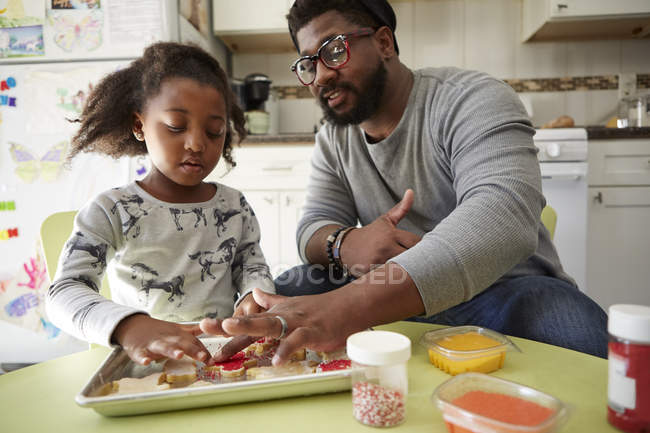 Padre e figlia decorare biscotti crudi — Foto stock