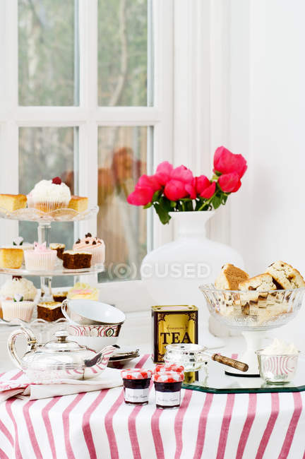Подається стіл з різними солодощами, тістечками та чаєм вдома — стокове фото