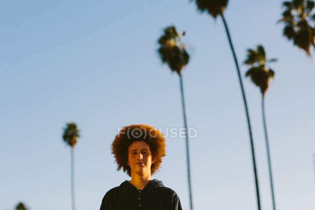 Portrait of teenage boy with red afro hair, outdoors — Stock Photo