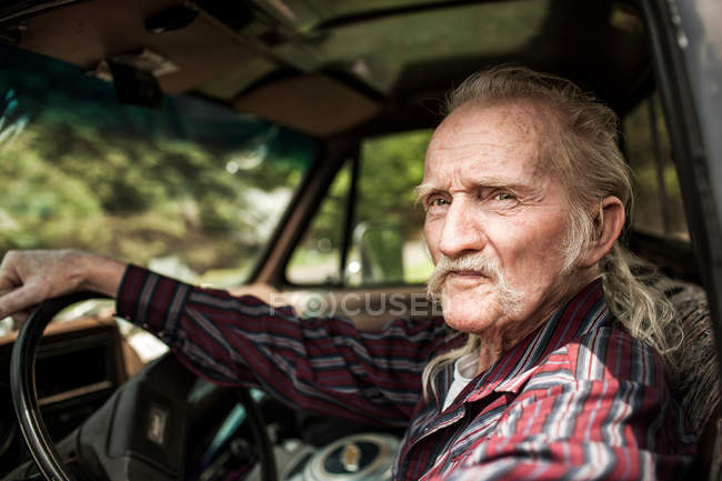 Портрет пожилого человека, сидящего в машине — стоковое фото
