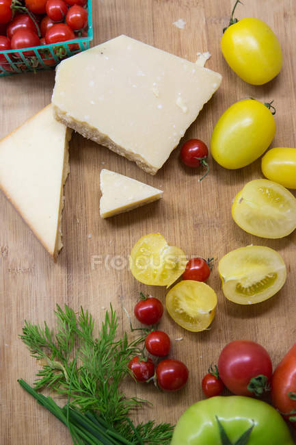 High angle view of red, green and yellow tomatoes with cheese on table — Stock Photo