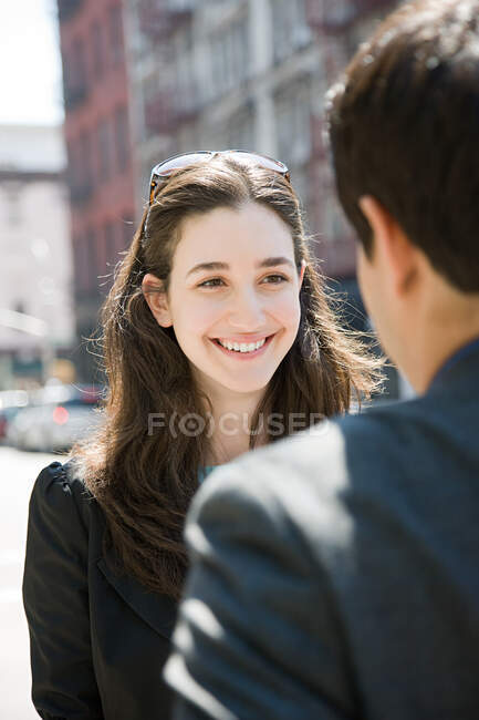 Jovem mulher sorrindo para um homem — Fotografia de Stock