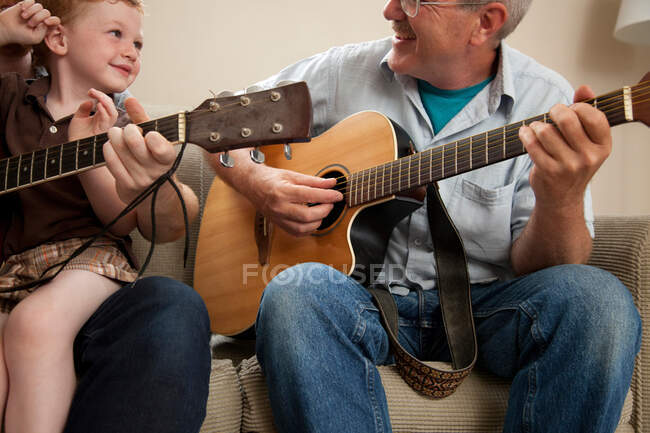 Menino e avô tocando guitarra — Fotografia de Stock