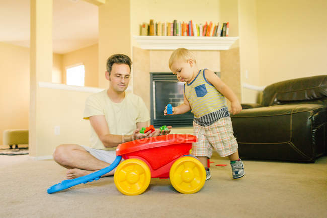 Vater und kleiner Sohn spielen zu Hause zusammen — Stockfoto