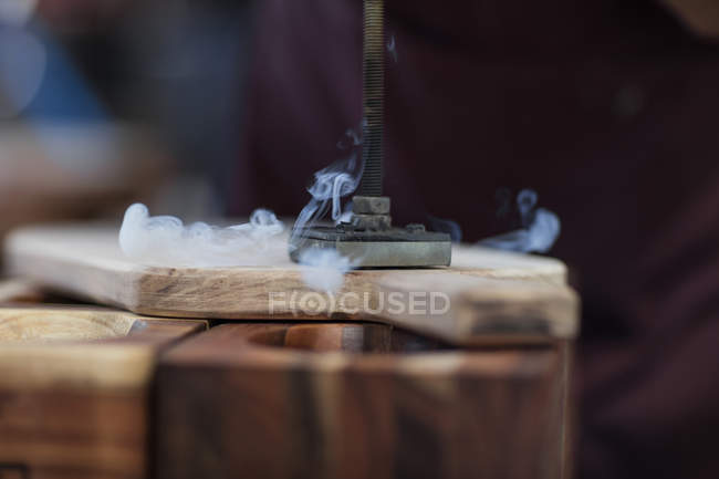 Cape Town, Sud Africa, branding ferro da stiro fumare su un tagliere di legno — Foto stock
