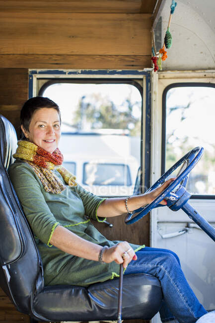 Portrait of mature hippy woman in driving seat of camper van — Stock Photo