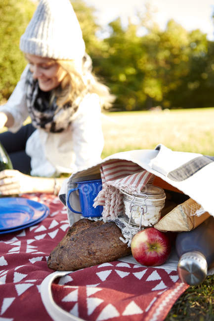Giovane donna sdraiata al picnic nel parco — Foto stock