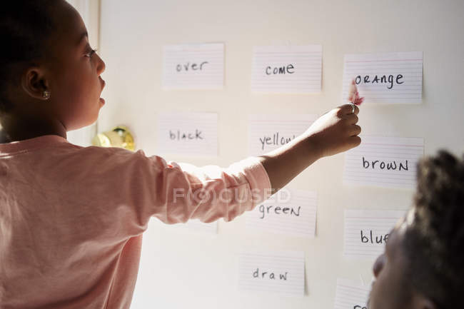 Девушка с отцом, указывающая на слова на стене — стоковое фото