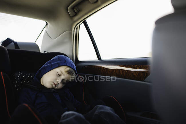 Giovane ragazzo che dorme nel sedile posteriore della macchina — Foto stock