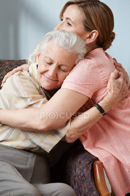 Hija y madre mayor abrazando - foto de stock