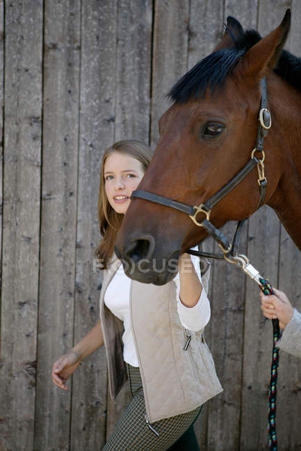 Молода жінка на чолі коня — стокове фото