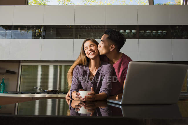 Loved up couple in dining room drinking coffee — Stock Photo