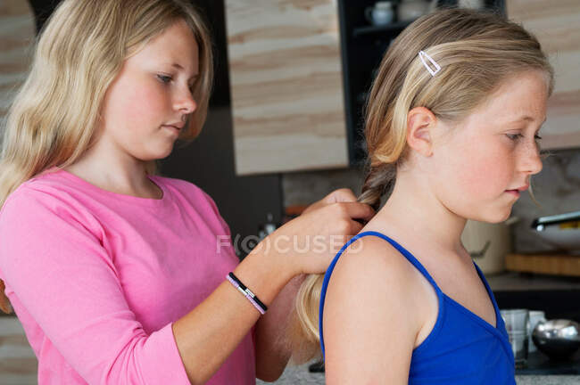 Menina entrançar amigos cabelo — Fotografia de Stock