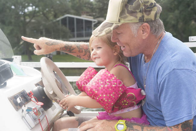 Filha ajudando o pai a dirigir barco de velocidade, Shalimar, Flórida, EUA — Fotografia de Stock