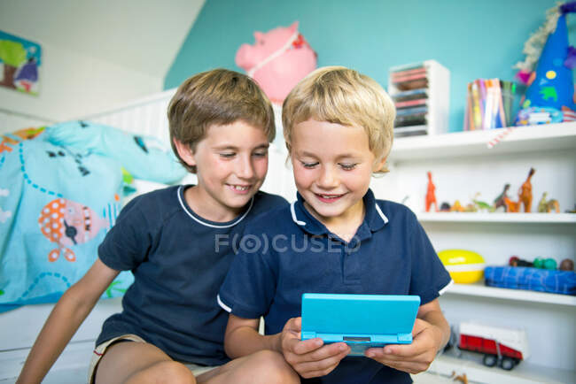 Hermanos con computadora portátil juego - foto de stock