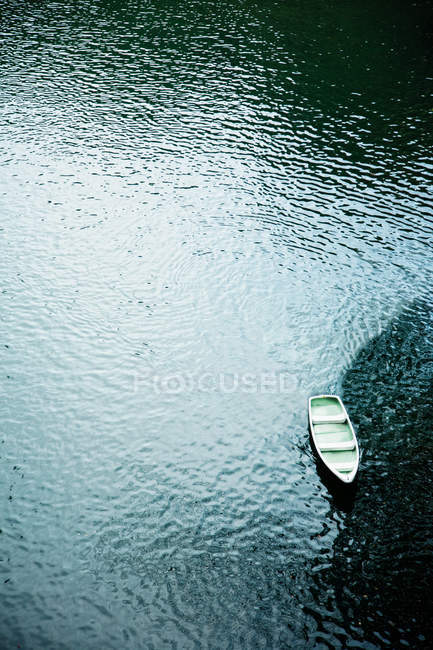 Повітряний вид на невеликий човен на поверхні хвилястої води — стокове фото