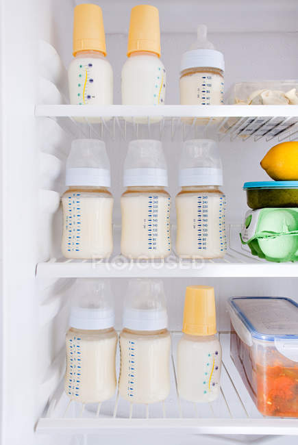 Bottles of breast milk in refrigerator — Stock Photo