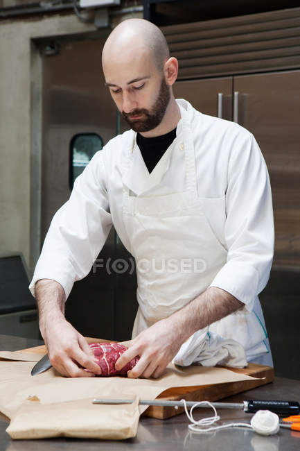 Мясник готовит говяжью вырезку — стоковое фото