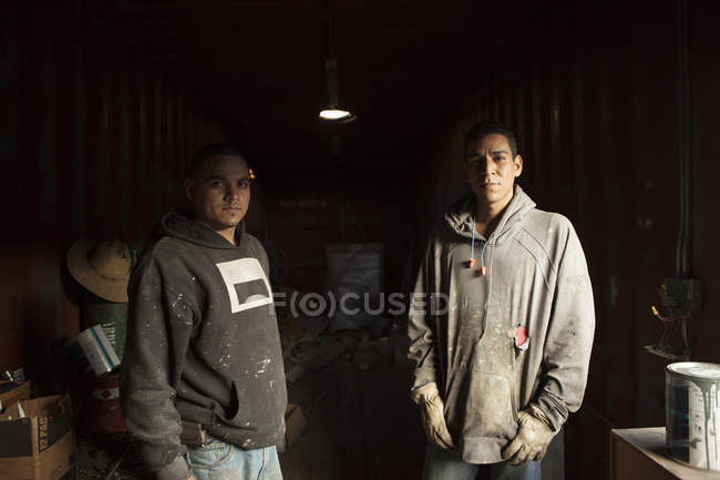 Porträt von Bauarbeitern im Schiffscontainer, die in die Kamera schauen — Stockfoto