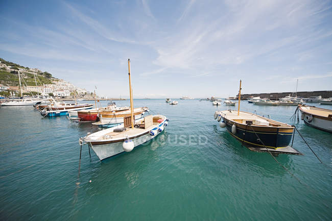 Boats in harbour under blue cloudy sky — Stock Photo