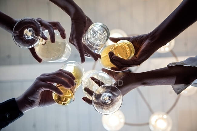 Grupo de amigos fazendo um brinde, vista para cima de mãos segurando óculos — Fotografia de Stock