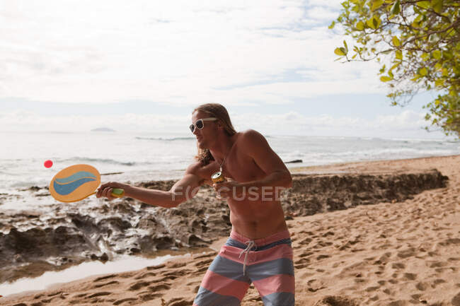 Homem jogando morcego e bola jogo na praia — Fotografia de Stock