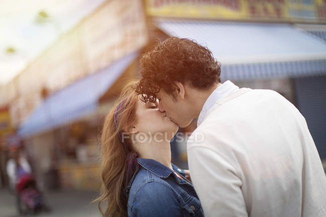 Casal romântico beijando no parque de diversões — Fotografia de Stock