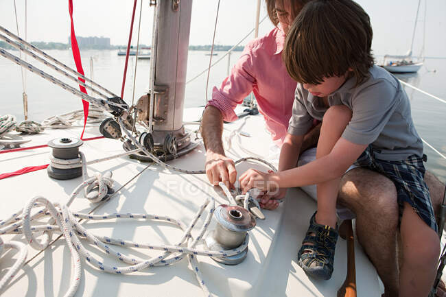Father and son on board yacht with rope — Stock Photo