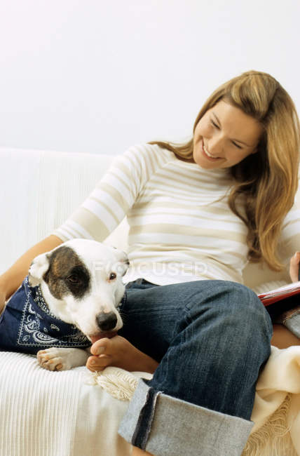Cão e senhora proprietário no sofá — Fotografia de Stock