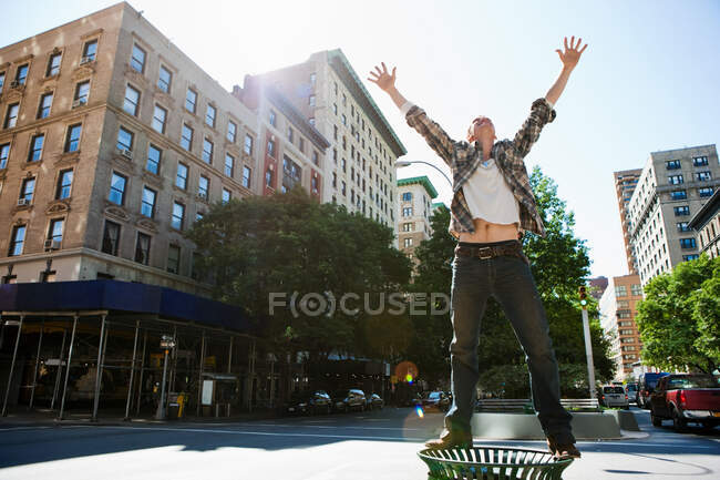 Mittlerer erwachsener Mann steht auf Mülltonne in der Stadt — Stockfoto
