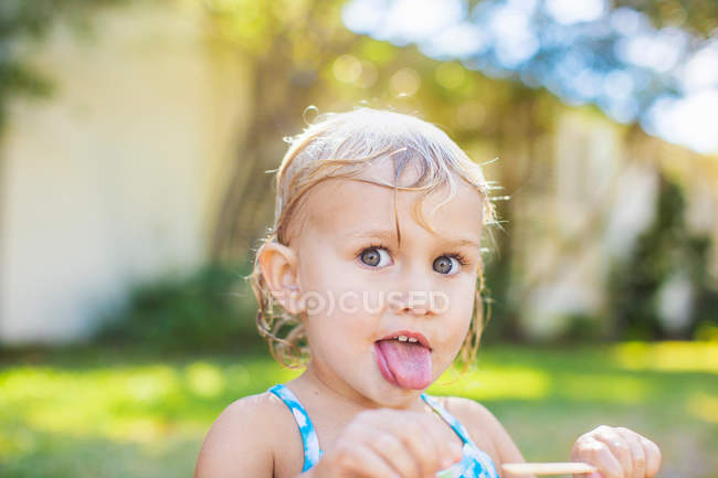 Menina com cabelo molhado lambendo gelo alegre — Fotografia de Stock