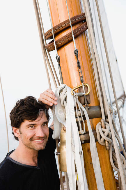 Mann sitzt an Deck eines Segelbootes — Stockfoto