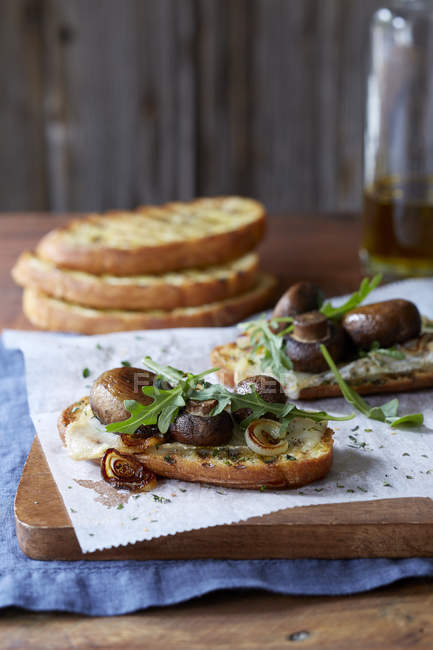 Bruschettas com cogumelos portobello, cebola torrada e arugula fresca — Fotografia de Stock